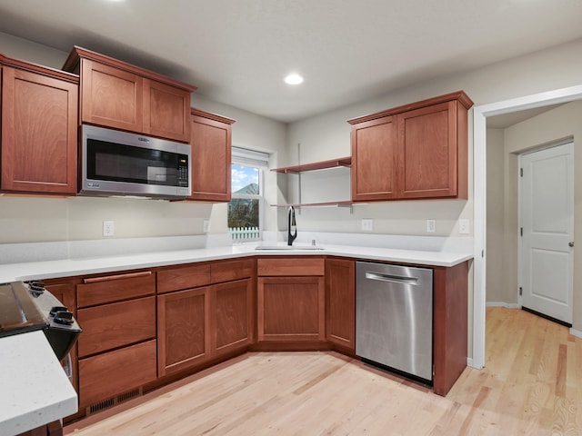 kitchen featuring sink, light hardwood / wood-style floors, and appliances with stainless steel finishes