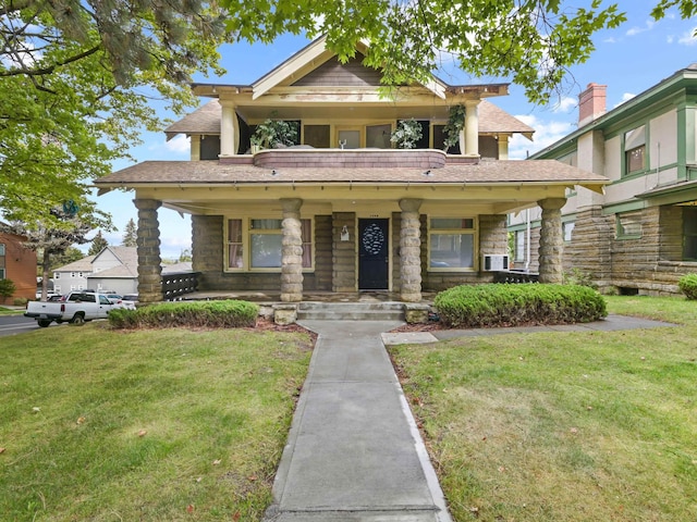 craftsman inspired home featuring covered porch, a balcony, and a front lawn