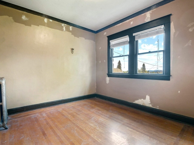 unfurnished room featuring hardwood / wood-style flooring and ornamental molding