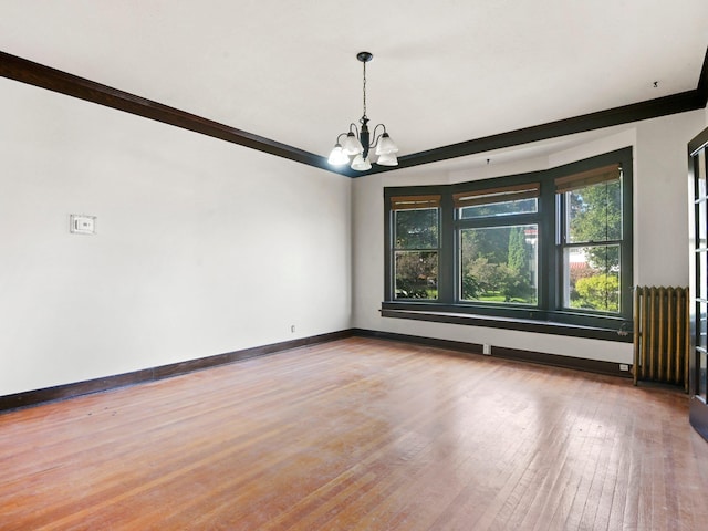 spare room with ornamental molding, radiator heating unit, a chandelier, and hardwood / wood-style flooring