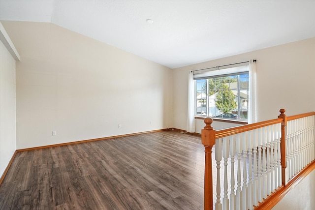 spare room featuring wood-type flooring and lofted ceiling