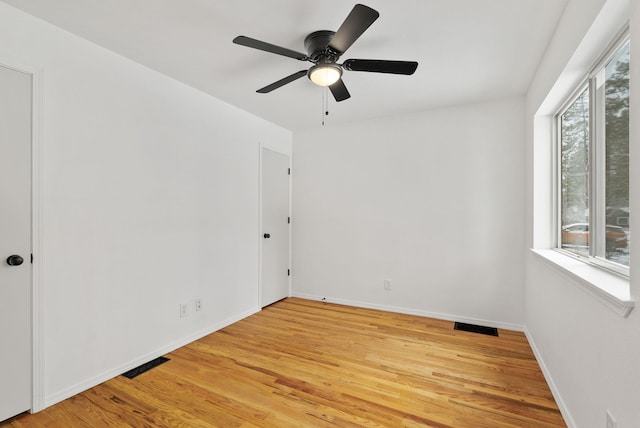 empty room featuring ceiling fan, light hardwood / wood-style flooring, and a healthy amount of sunlight