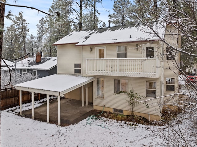 snow covered property with a balcony