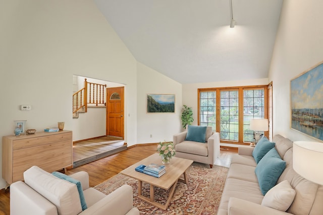 living room with hardwood / wood-style floors and high vaulted ceiling