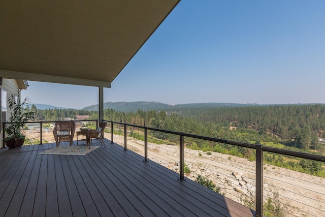 wooden terrace featuring a mountain view and a wooded view