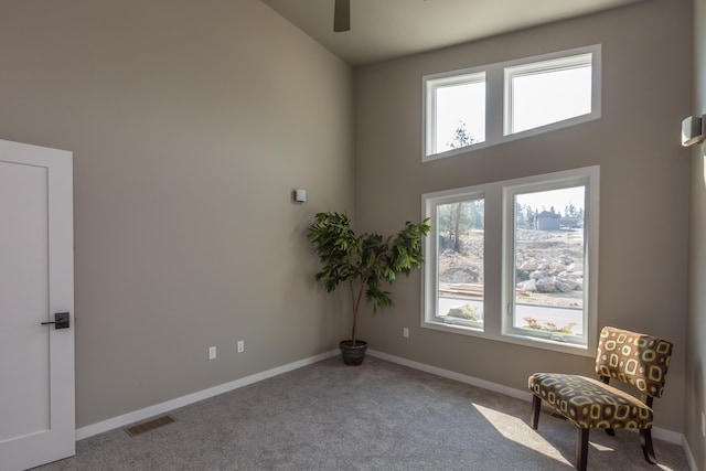 living area featuring a ceiling fan, carpet, visible vents, and baseboards