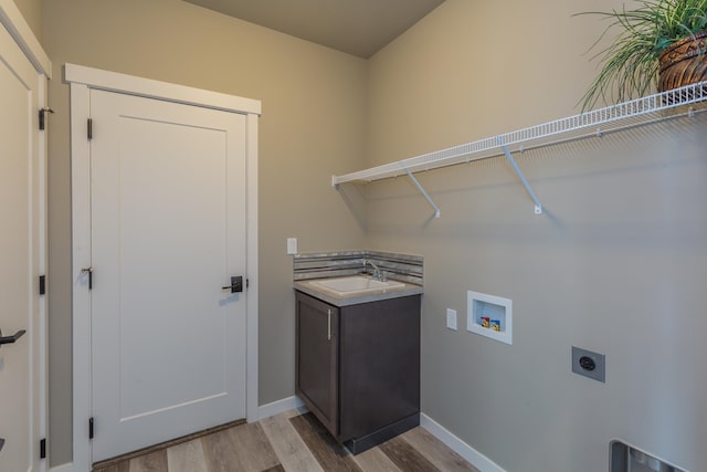 laundry room with hookup for a washing machine, light wood-style flooring, hookup for an electric dryer, a sink, and laundry area