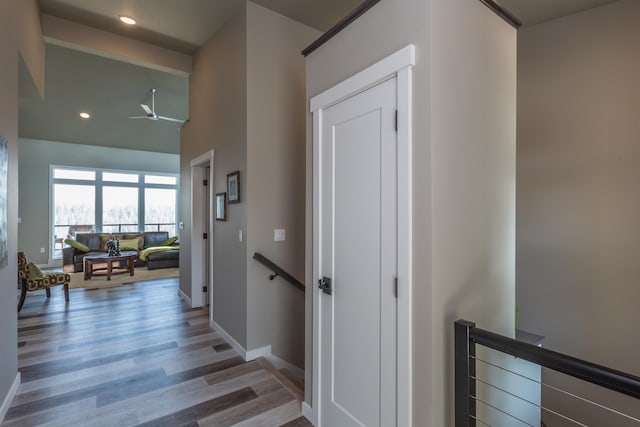 hallway featuring recessed lighting, wood finished floors, an upstairs landing, and baseboards