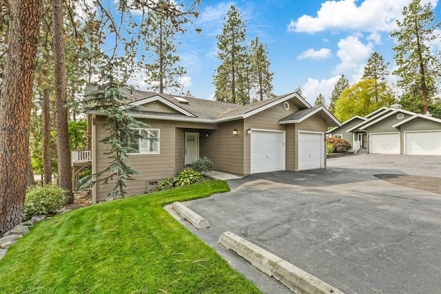 ranch-style house featuring a garage and a front lawn