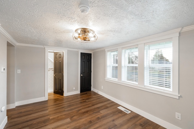 unfurnished bedroom featuring a textured ceiling, dark hardwood / wood-style floors, and ornamental molding