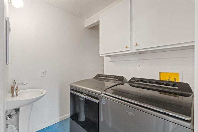 washroom with cabinets, independent washer and dryer, sink, and light tile patterned floors