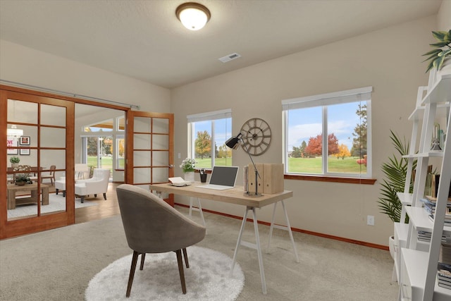 home office with light colored carpet and french doors