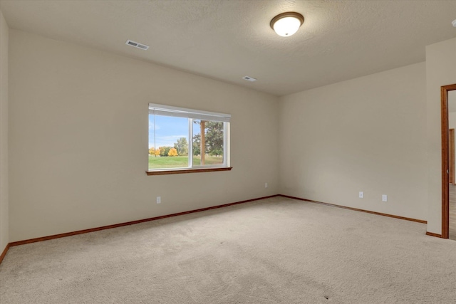 carpeted empty room featuring a textured ceiling