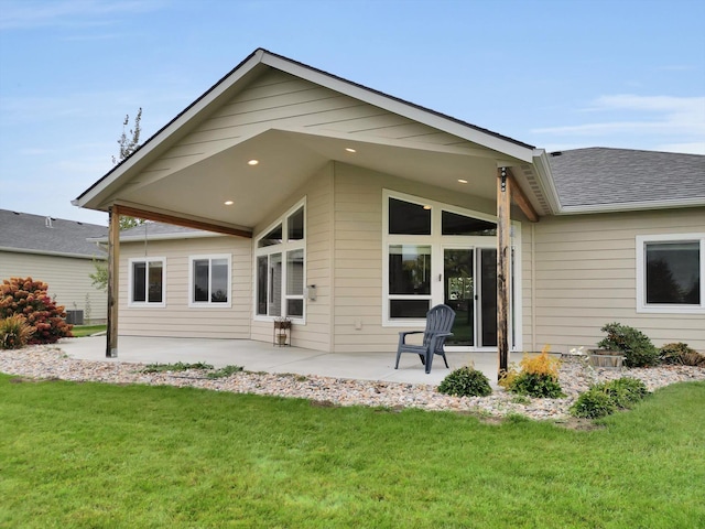 rear view of property featuring a yard, a patio, and central AC unit