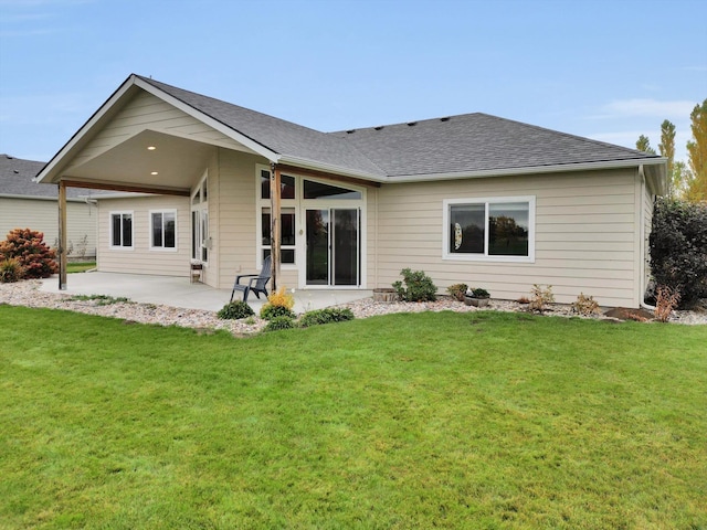 rear view of house featuring a lawn and a patio