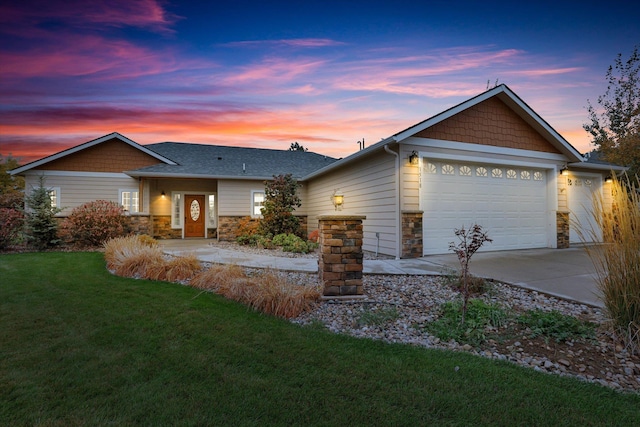 single story home featuring a garage and a lawn