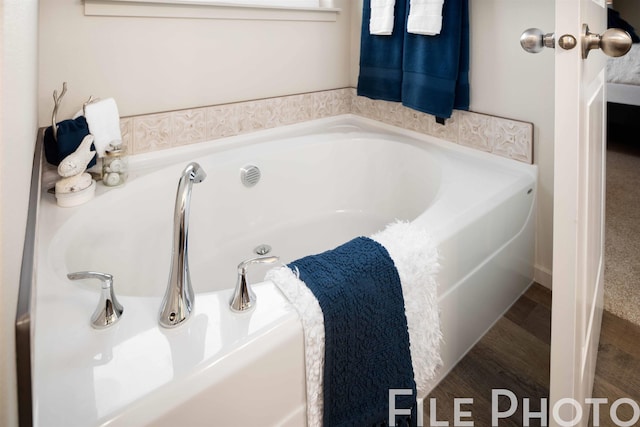 bathroom featuring a tub to relax in and wood-type flooring