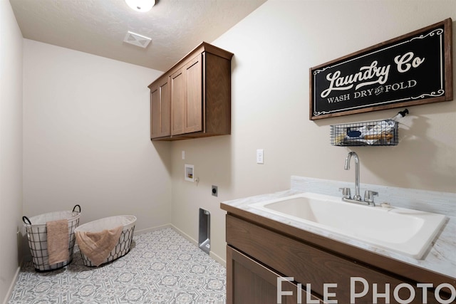 clothes washing area featuring sink, cabinets, washer hookup, hookup for an electric dryer, and a textured ceiling