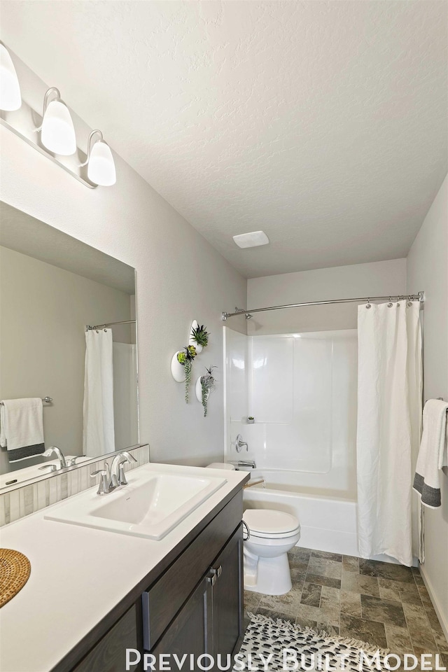 full bathroom featuring vanity, shower / bathtub combination with curtain, a textured ceiling, and toilet