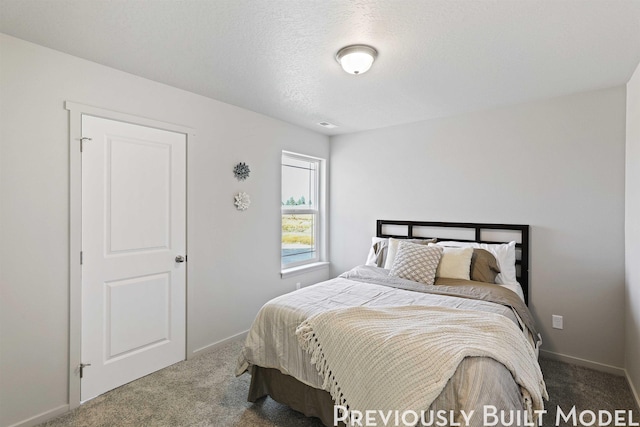 bedroom featuring carpet flooring and a textured ceiling