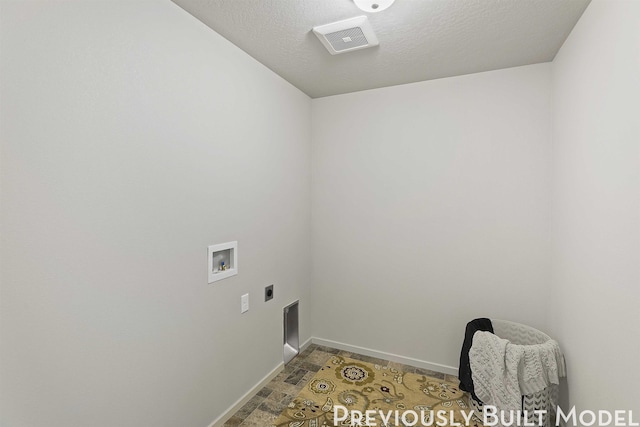 clothes washing area featuring hookup for an electric dryer, hookup for a washing machine, and a textured ceiling