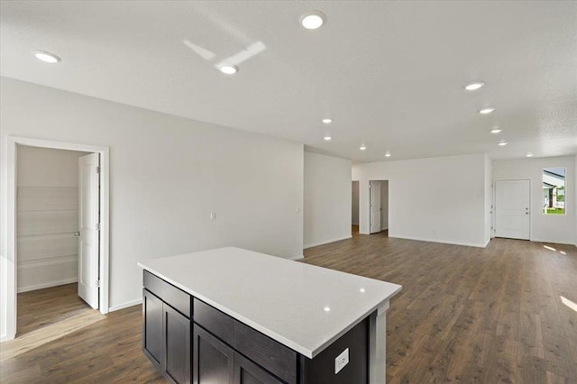 kitchen featuring light countertops, dark wood-style flooring, recessed lighting, and a center island