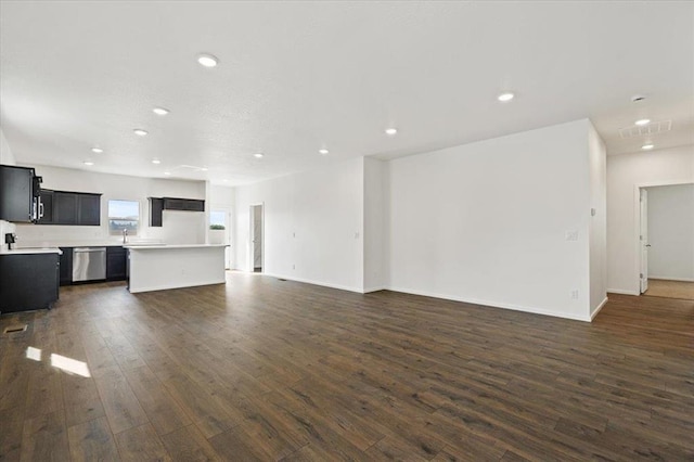 unfurnished living room with baseboards, visible vents, dark wood-style flooring, and recessed lighting