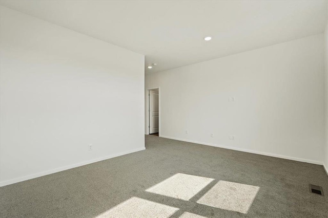 unfurnished room with carpet, visible vents, baseboards, and recessed lighting