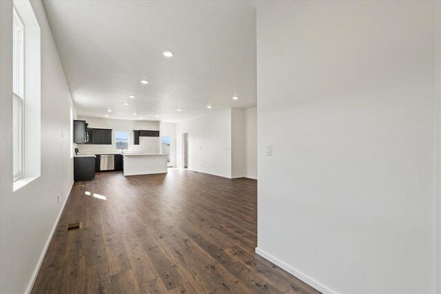 unfurnished living room with dark hardwood / wood-style flooring and a healthy amount of sunlight