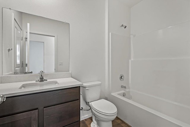 bathroom with wood finished floors, vanity, toilet, and bathing tub / shower combination