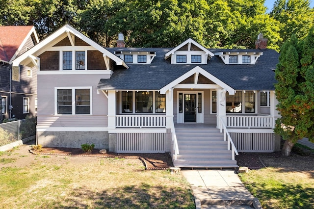 view of front of house with covered porch and a front lawn