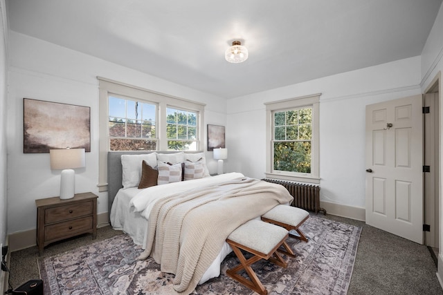 bedroom featuring dark carpet, radiator heating unit, and multiple windows