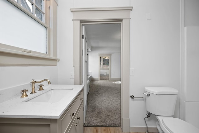 bathroom featuring wood-type flooring, vanity, and toilet