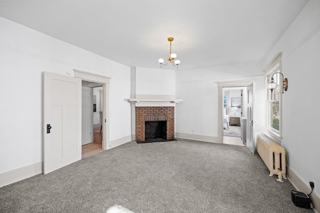 unfurnished living room with a chandelier, carpet floors, a brick fireplace, and radiator