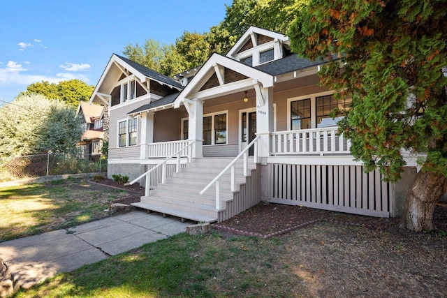 view of front of house featuring covered porch and a front lawn