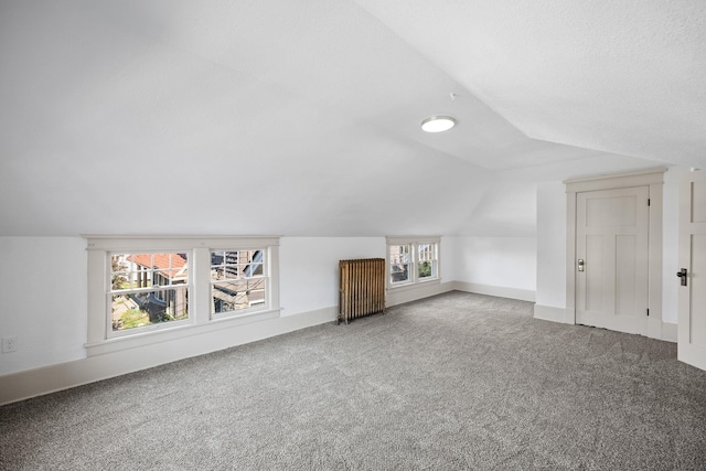 bonus room featuring carpet flooring, radiator heating unit, and vaulted ceiling