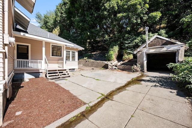 view of patio / terrace featuring an outbuilding, a garage, and covered porch