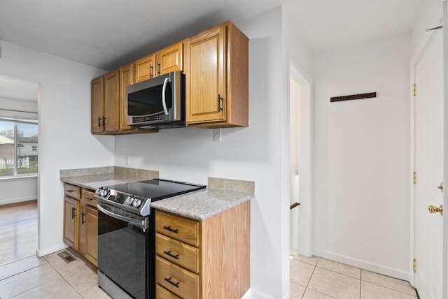 kitchen featuring light tile patterned floors and stainless steel appliances