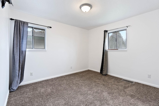 unfurnished room featuring dark carpet