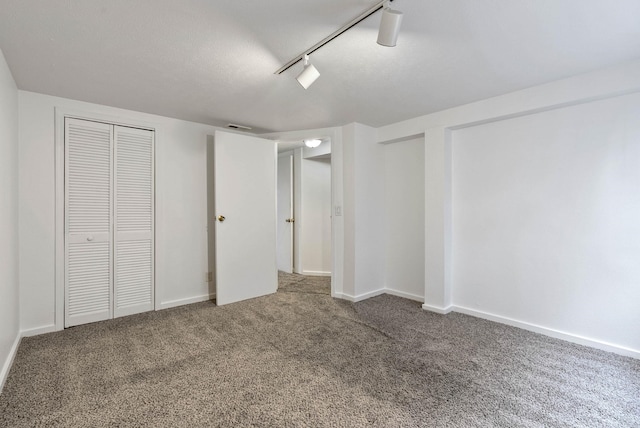 unfurnished bedroom with carpet floors and rail lighting