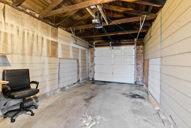 garage with wood walls and a garage door opener