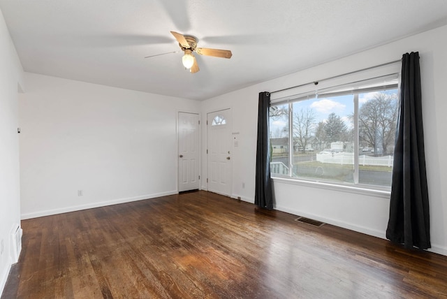 empty room with ceiling fan and dark hardwood / wood-style floors