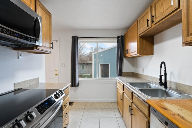 kitchen featuring sink, light tile patterned floors, and stainless steel appliances