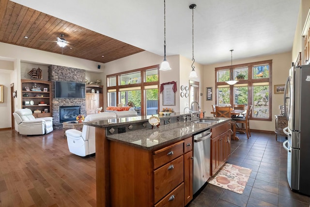 kitchen featuring stainless steel appliances, sink, decorative light fixtures, wooden ceiling, and dark stone countertops