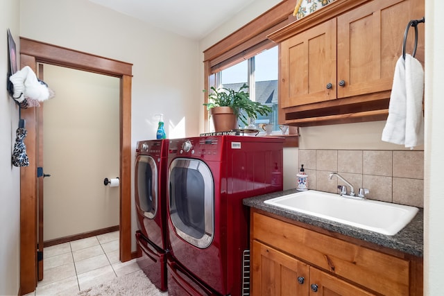 laundry area with light tile patterned flooring, cabinets, separate washer and dryer, and sink