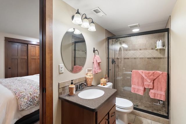 bathroom with tile patterned flooring, vanity, toilet, and a shower with shower door