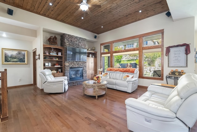 living room featuring ceiling fan, built in features, wood-type flooring, a fireplace, and wood ceiling