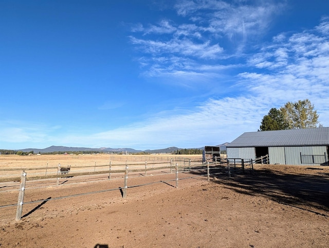 view of yard featuring an outbuilding, a mountain view, and a rural view