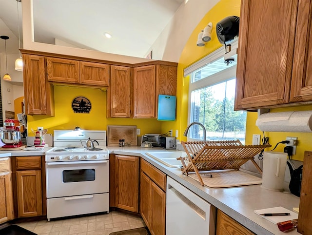 kitchen with lofted ceiling, sink, white appliances, and decorative light fixtures