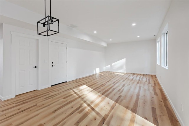 kitchen featuring pendant lighting, a kitchen island, stainless steel appliances, and light hardwood / wood-style floors